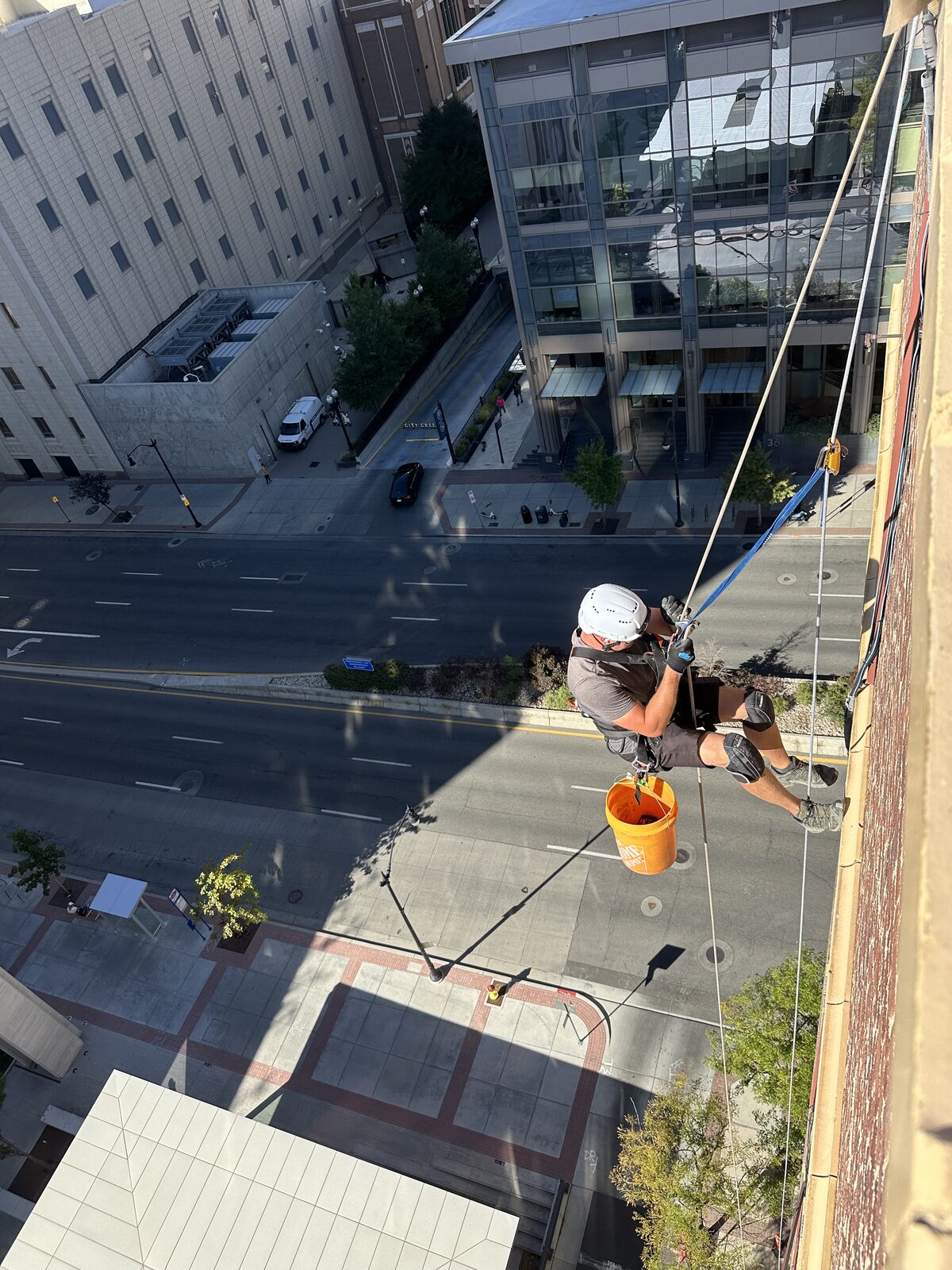 Technician descending a tall building for exterior access